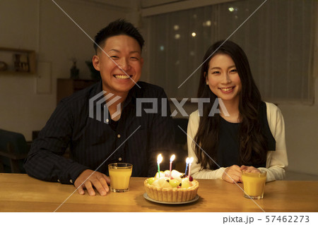 フルーツケーキで誕生日を祝う若いカップルの写真素材