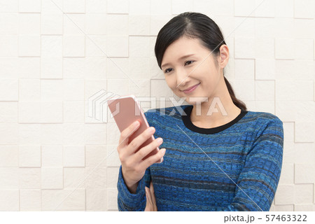 スマートフォンを持つ笑顔の女性 57463322
