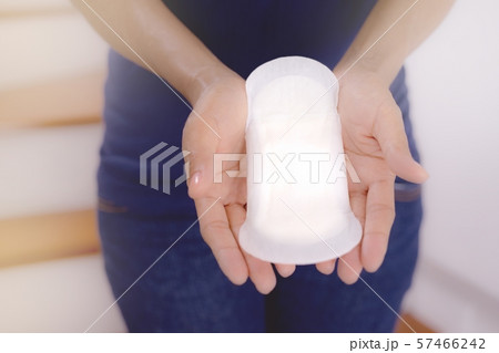 Woman wearing t-shirt holding menstrual pad.Female Hygiene concept. 57466242