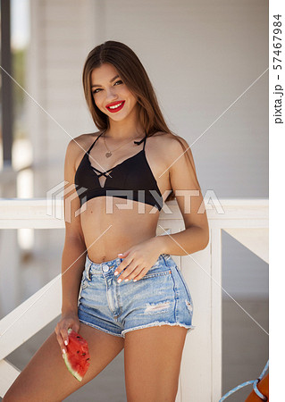 Fashion portrait of a sexy girl with watermelon on the beach Fashion portrait of a sexy girl with watermelon on the beach 57467984