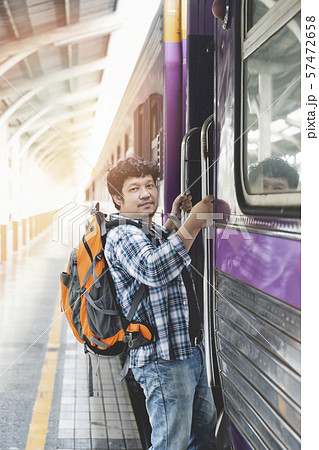 Asian man traveler with backpack is stepping up the train in train station. 57472658