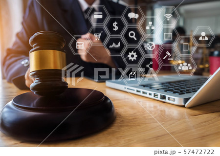 Justice and law concept. Male judge in a courtroom with the gavel working with digital tablet computer docking keyboard on wood table. 57472722