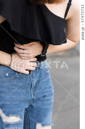 Young asian woman suffering pain on stomach while Young asian woman suffering pain on stomach while 57472732