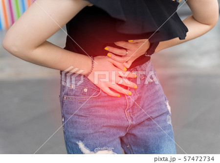 Young asian woman suffering pain on stomach while 57472734