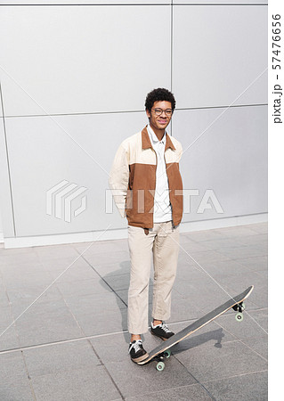 Full-length photo of afro skateboarder with board 57476656