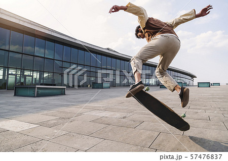 Afro skateboarder doing trick jumping high in air 57476837