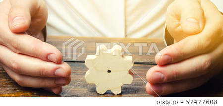 Businessman and wooden gear. Establishing business 57477608