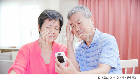 elder couple measure blood glucose 57479445