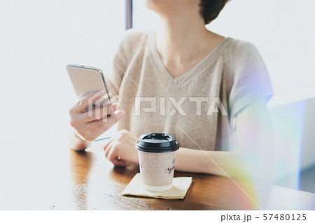 スマホを使用する女性 カフェ コーヒー 57480125