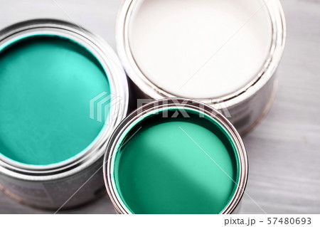 Several opened cans with green paint inside. 57480693