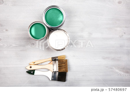green paint cans and colored brushes on white background 57480697