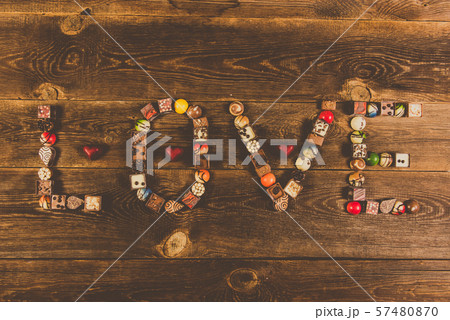 LOVE word arranged with pralines on the wooden LOVE word arranged with pralines on the wooden 57480870