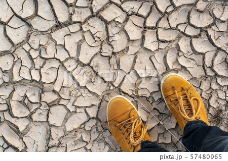 Human legs standing on dried cracked earth 57480965