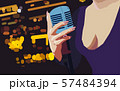 Female hand holding a single retro microphone against colourful background. 57484394