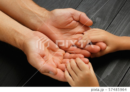 Hands of elderly man holding hand of younger man Hands of elderly man holding hand of younger man 57485964