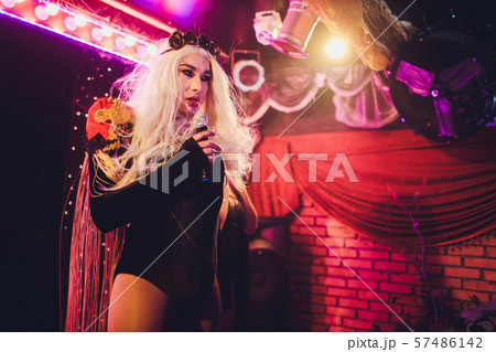 Portrait of young transgender woman in bright costume on color background. 57486142