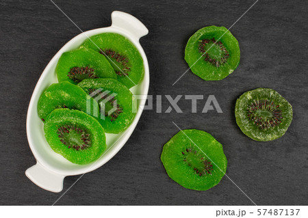 Sweet candied kiwifruit on grey stone Sweet candied kiwifruit on grey stone 57487137