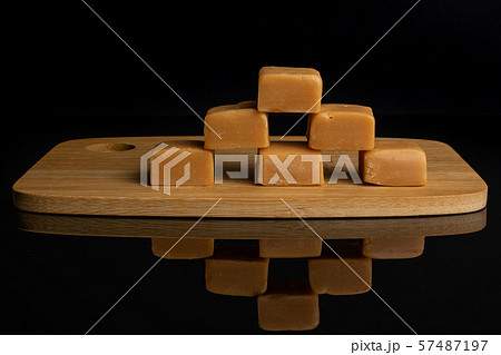 Sweet caramel candy isolated on black glass Sweet caramel candy isolated on black glass 57487197