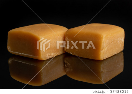 Sweet caramel candy isolated on black glass Sweet caramel candy isolated on black glass 57488015
