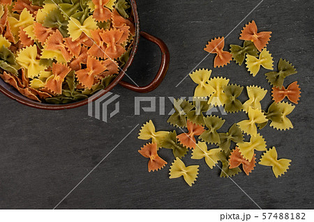 Raw farfalle tricolore on grey stone 57488182
