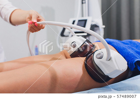Cropped view of cosmetologist with roller doing buttocks starvac massage. 57489007