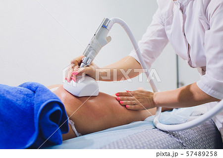 Cropped view of cosmetologist with roller doing buttocks starvac massage. 57489258