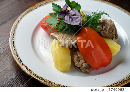 Boiled meat with a side dish and vegetables . restaurant menu 57490624
