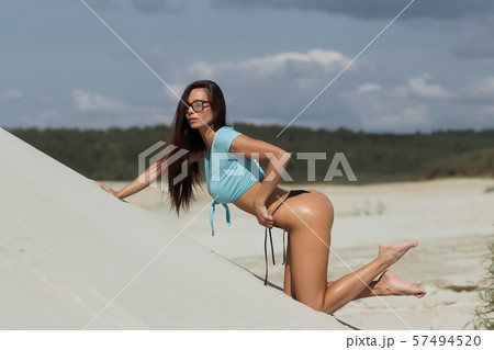 Hot woman in stylish swimsuit leaning on surface Hot woman in stylish swimsuit leaning on surface 57494520