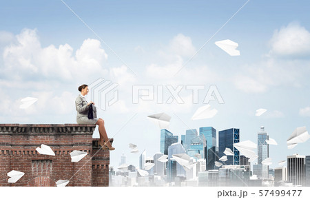 Businesswoman or accountant on building top and paper planes flying around. Mixed media Businesswoman or accountant on building top and paper planes flying around. Mixed media 57499477