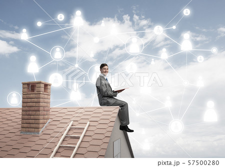 Man on roof reading book and concept of social connection Man on roof reading book and concept of social connection 57500280