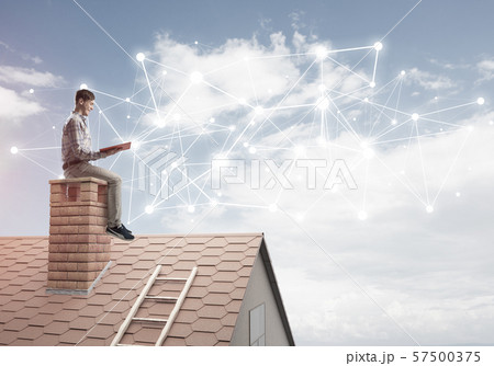 Man on brick roof reading book and concept of social connection 57500375