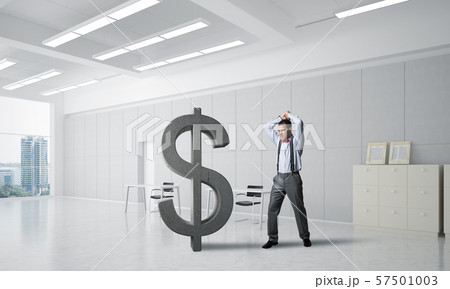 Determined banker man in modern office interior breaking dollar figure 57501003