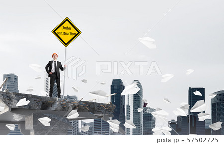 Confident engineer holding street safety sign. Confident engineer holding street safety sign. 57502725