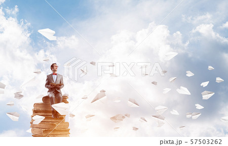 Young businessman or student in blue sky studying the science Young businessman or student in blue sky studying the science 57503262