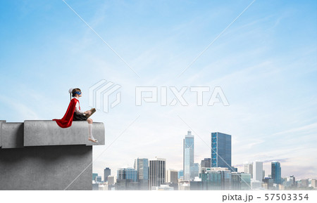 Girl power concept with cute kid guardian against cloudscape background . Mixed media 57503354