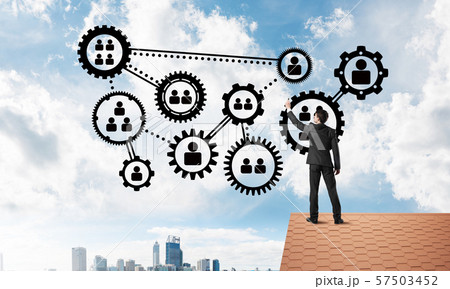 Businessman on house roof presenting teamwork and connection concept. Mixed media 57503452