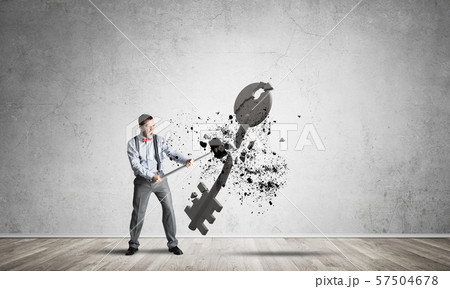 Breaking through access concept with man in room crashing concrete key 57504678