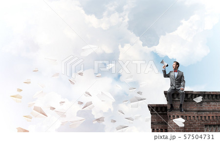 Businessman or manager announcing something in loudspeaker and paper planes fly around 57504731