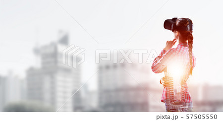 Girl in checked shirt wearing VR glasses experiencing another reality 57505550