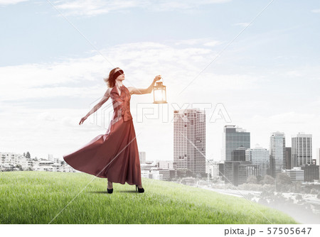 Attractive girl muse with old lantern in hand at summer day 57505647