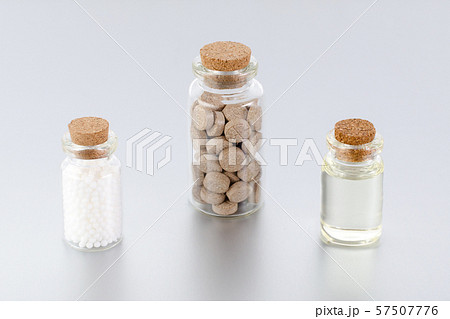 natural medicine bottles with herbal pills, globules and oil on gray background natural medicine bottles with herbal pills, globules and oil on gray background 57507776