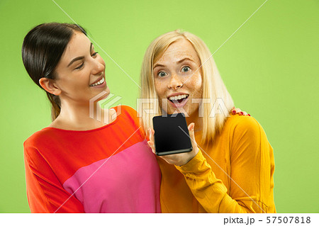 Portrait of pretty girls isolated on green studio background 57507818