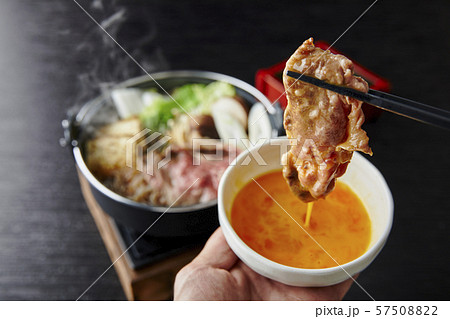 すき焼きの肉を溶き卵につけてるところ 57508822