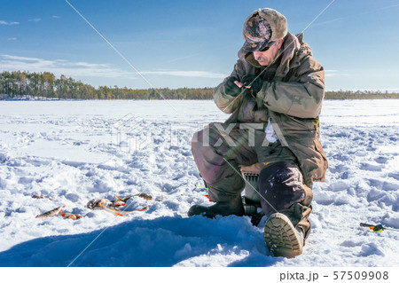 winter fishing Fisherman enjoying a day on the ice winter fishing Fisherman enjoying a day on the ice 57509908