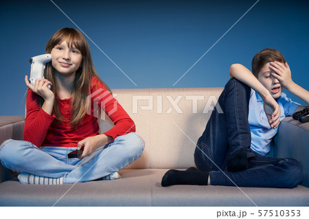 Gaming concept. Tired children on sofa with game joysticks Gaming concept. Tired children on sofa with game joysticks 57510353