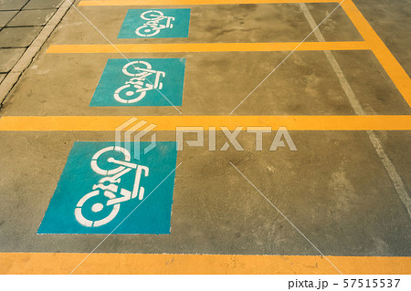 A white painting of a bicycle on the asphalt of the road that means mark of bicycle parking area. A white painting of a bicycle on the asphalt of the road that means mark of bicycle parking area. 57515537
