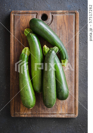 Freshly harvested zucchini, green vegetables on dark background, summer squash. Freshly harvested zucchini, green vegetables on dark background, summer squash. 57517262