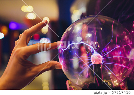 Hand touching a plasma ball with smooth magenta-blue flames. Hand touching a plasma ball with smooth magenta-blue flames. 57517416