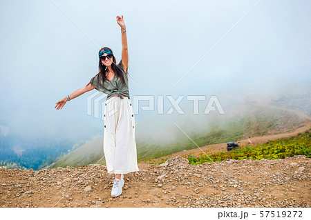 Beautiful happy young woman in mountains in the background of fog 57519272