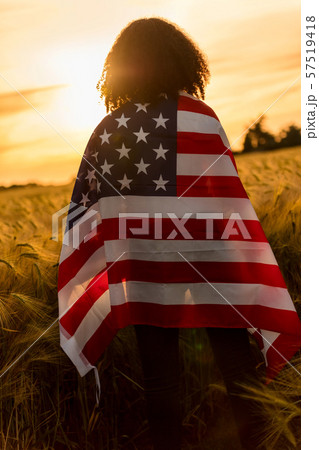 Girl TeenagerFemale Young Woman Wrapped in USA Flag at Sunset 57519418